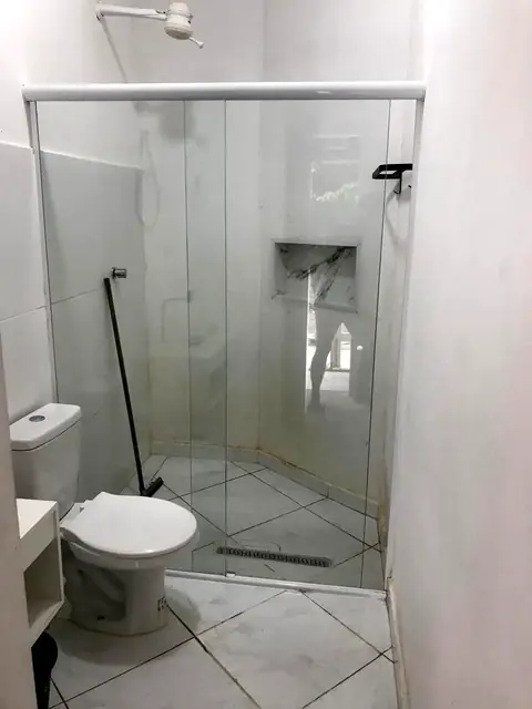 Banheiro claro com box de vidro